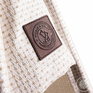 A close-up of the leather seal of quality on a Pickle & Polly Pet Teepee Bed (White).