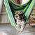 A cool dog wearing sunglasses hanging out in a hammock.