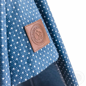A close-up of the leather seal of quality on a Pickle & Polly Pet Teepee Bed (Blue).