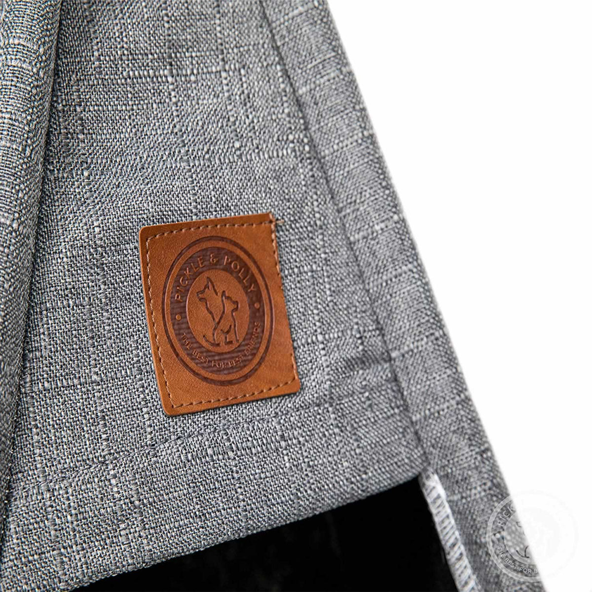 A close-up of the leather seal of quality on a Pickle & Polly Pet Teepee Bed (Gray).