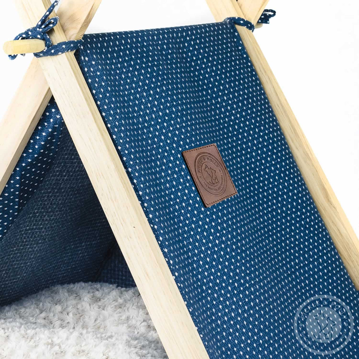 A close-up of the leather seal of quality on a Pickle & Polly Pet Tent (Blue).